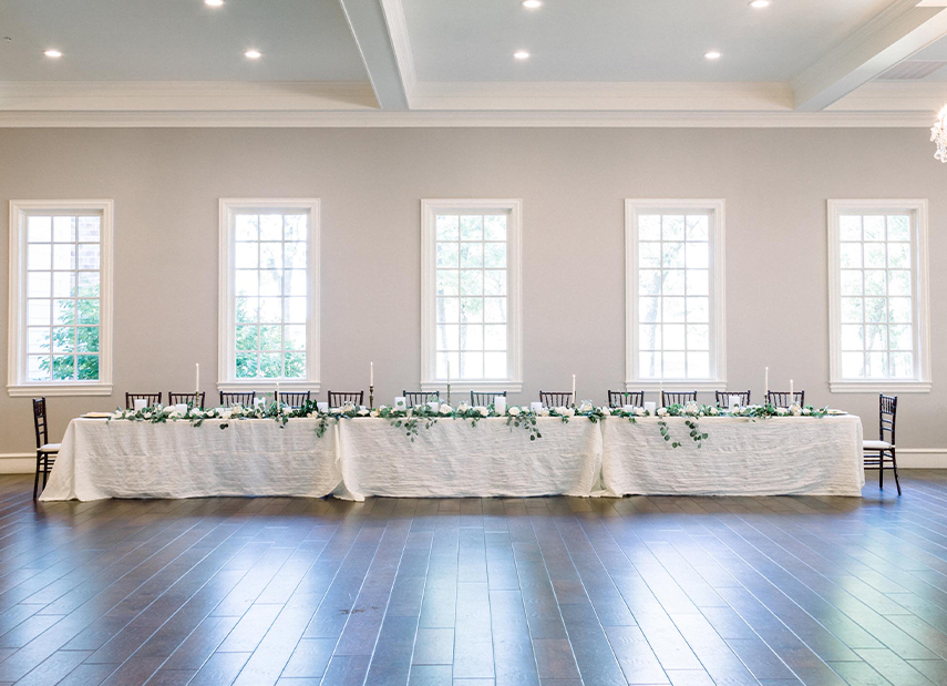 Light grey airy ballroom with long banquet table