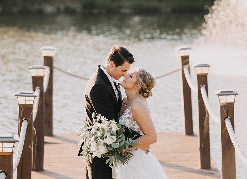 Bride and Groom Embrace on Dock Water Background
