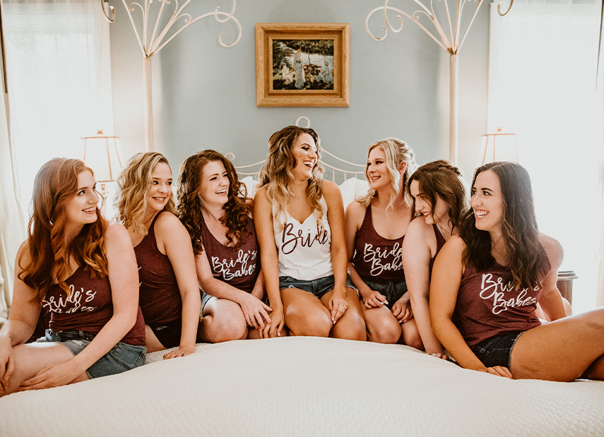 bridal party smiling on bed