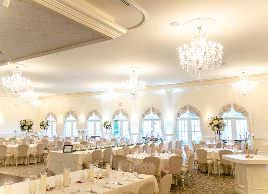 Wedding reception space with multiple tables and chandeliers