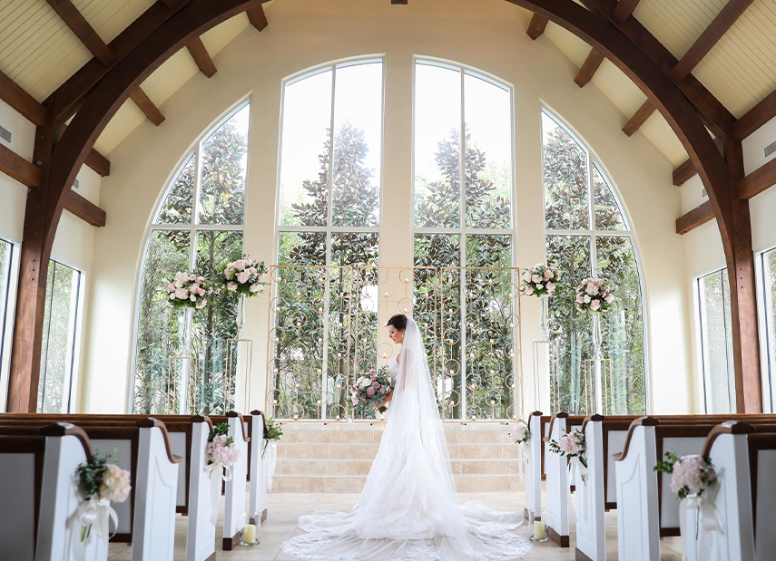 Bride in wedding ceremony space in front of large windows
