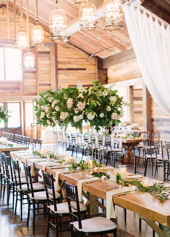 Long tables decorated with flowers in wedding reception space