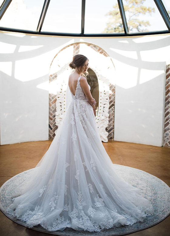 Bride wearing wedding dress in sun-filled room