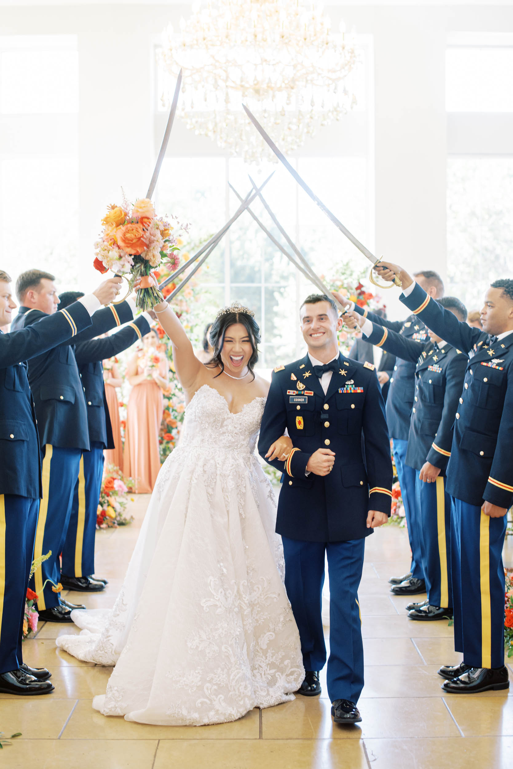 Bride and groom in military uniform walking past marines with swords