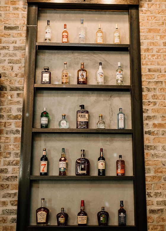 Shelves of wine and liquor behind bar