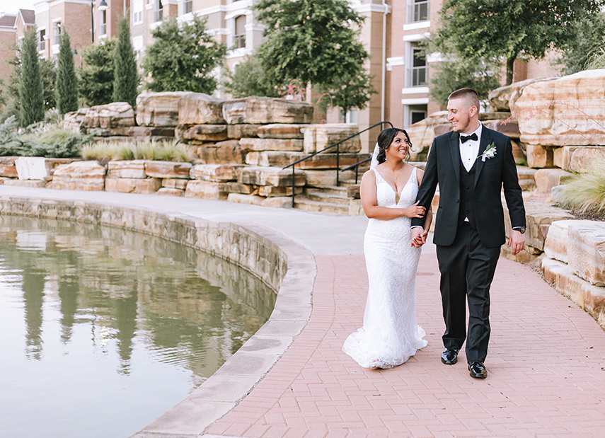 Stunning Black Bride Walks Along Water Brick Path with Husband