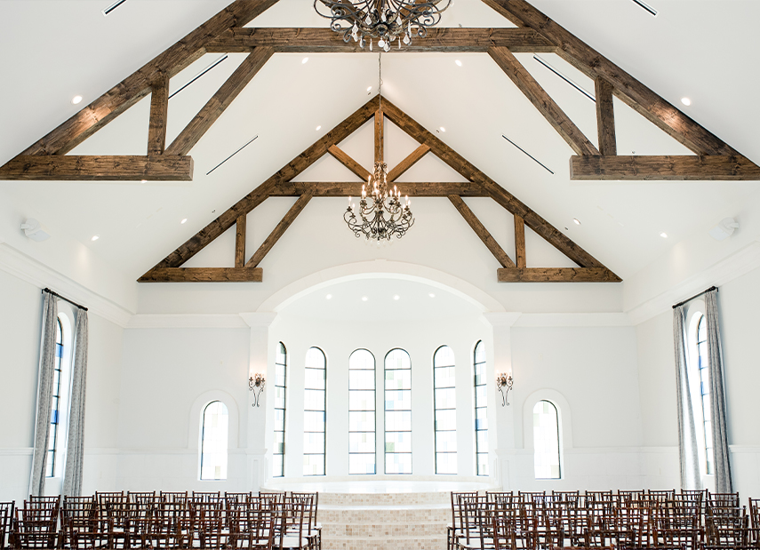 Natural Light Filled White Riverwalk Chapel Interior Large Arched Windows Chandelier Wooden Beams