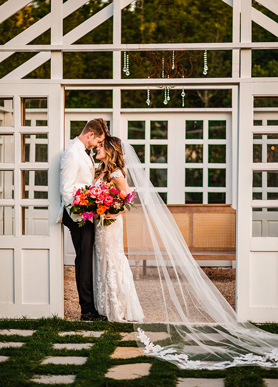 Bride Groom Embrace Vibrant Pink Bouquet Sunset White Outdoor Conservatory