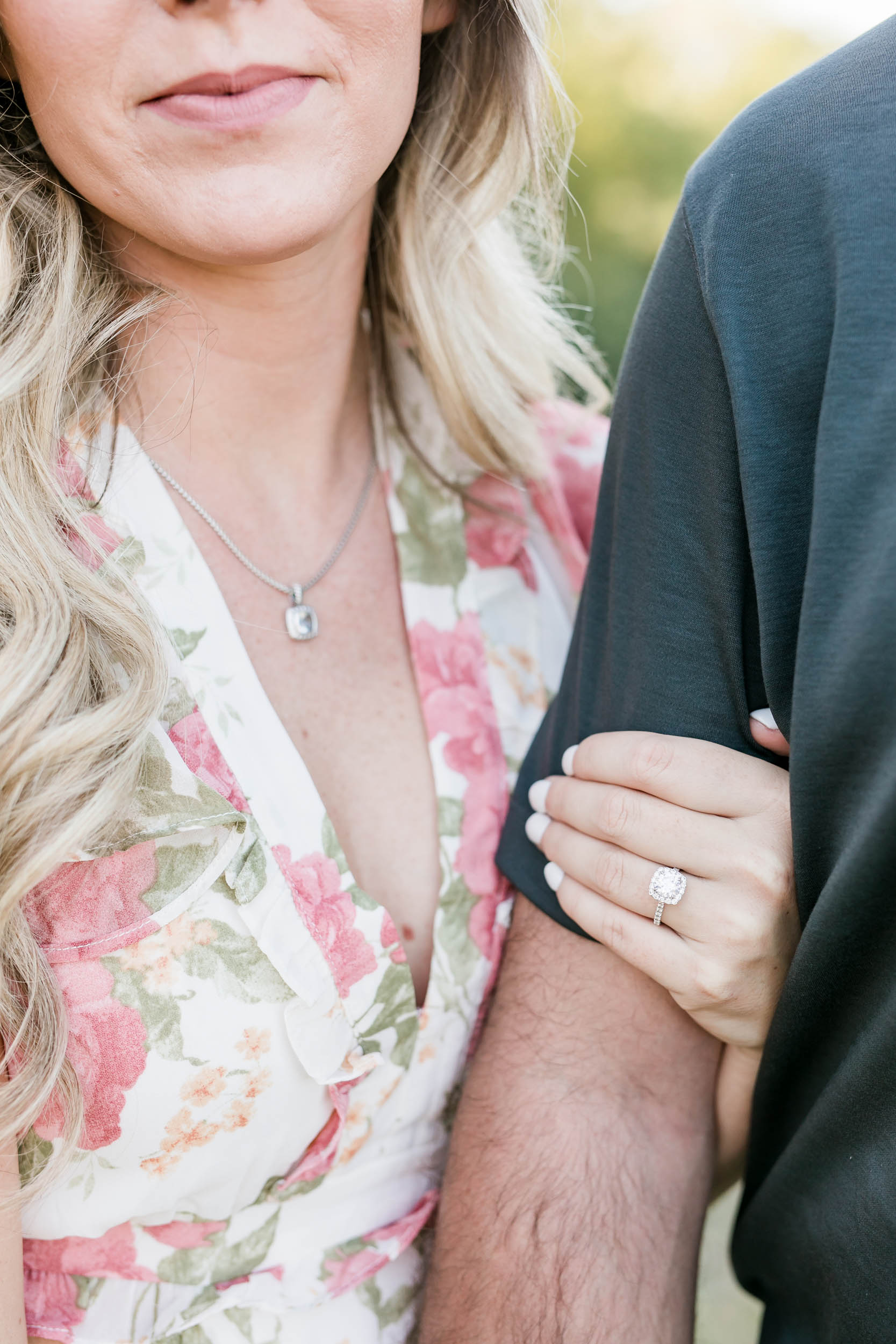 Couple posing with engagement ring on woman's hand